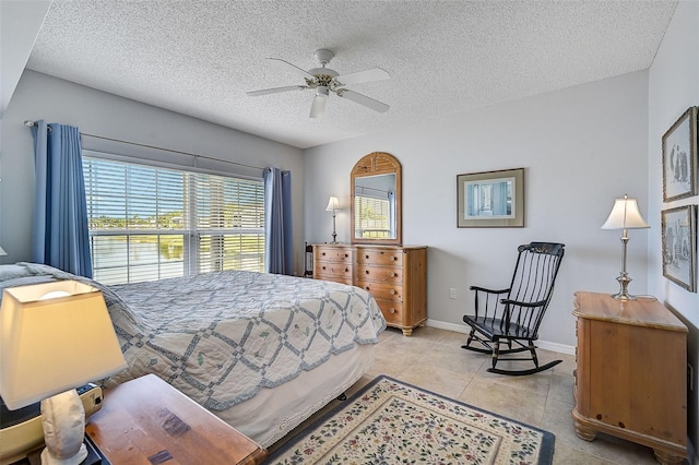 bedroom featuring a textured ceiling, ceiling fan, and light tile floors