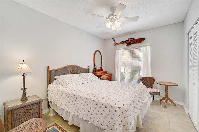 tiled bedroom with a textured ceiling, a closet, and ceiling fan