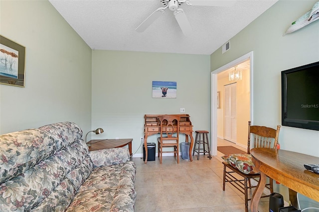 tiled living room with a textured ceiling and ceiling fan