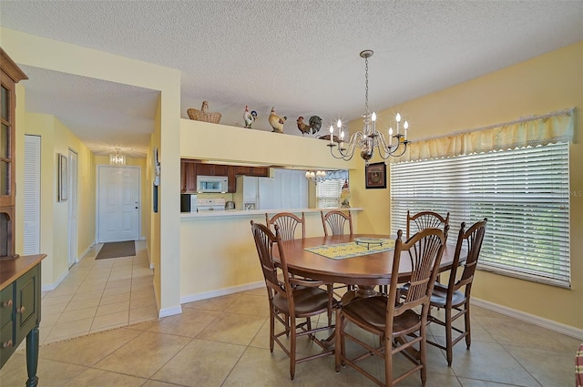 tiled dining room featuring a notable chandelier and a textured ceiling