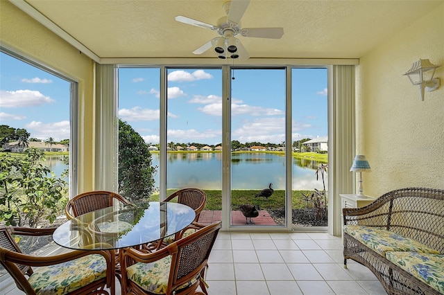 sunroom featuring a water view and ceiling fan