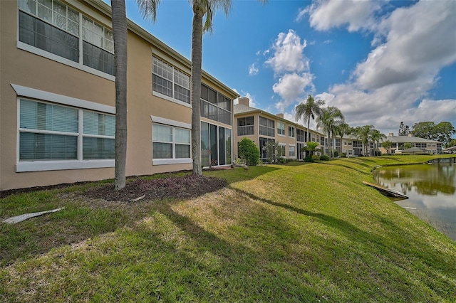 view of property's community featuring a lawn and a water view