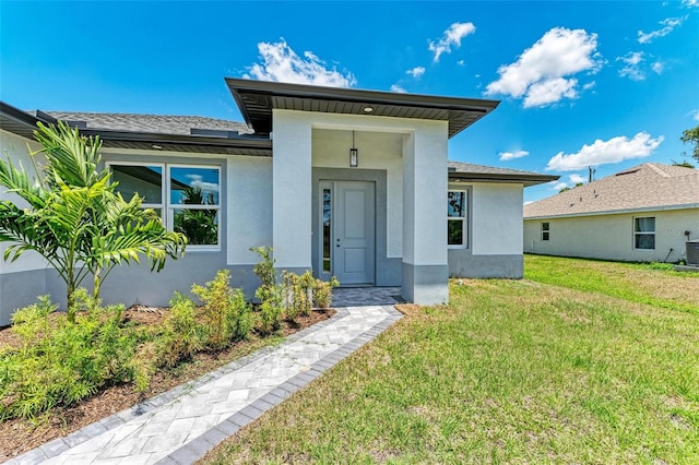 view of front of home featuring a front yard and central AC unit