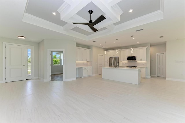 kitchen with decorative light fixtures, stainless steel appliances, a center island with sink, coffered ceiling, and white cabinetry