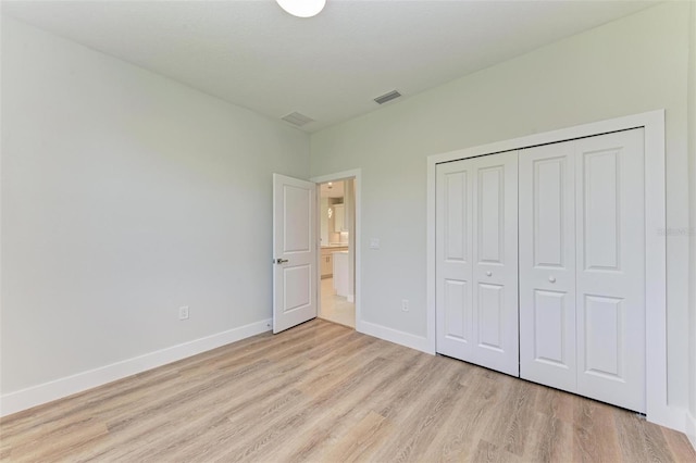 unfurnished bedroom featuring a closet and light hardwood / wood-style flooring