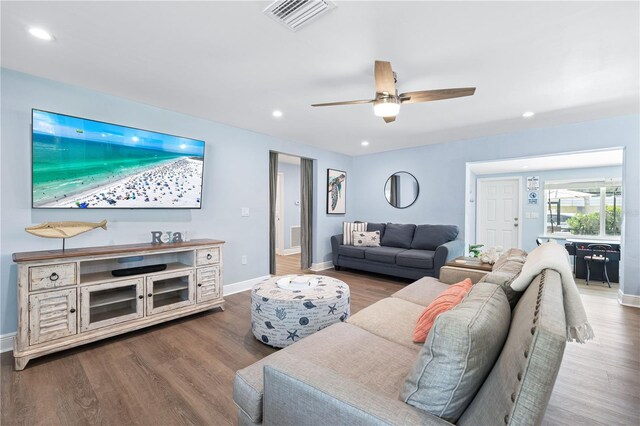 living area featuring visible vents, baseboards, and wood finished floors