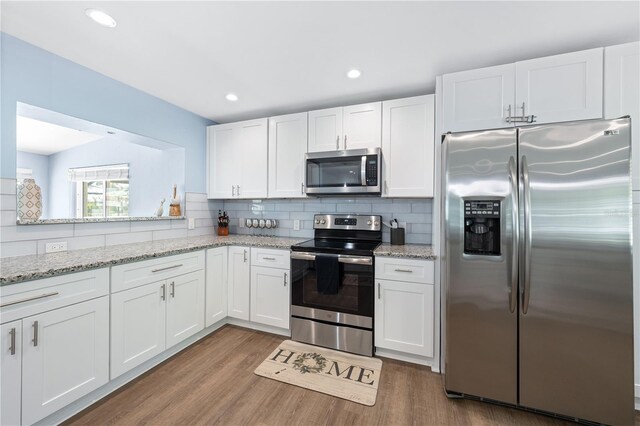 kitchen featuring stainless steel appliances, tasteful backsplash, and white cabinetry