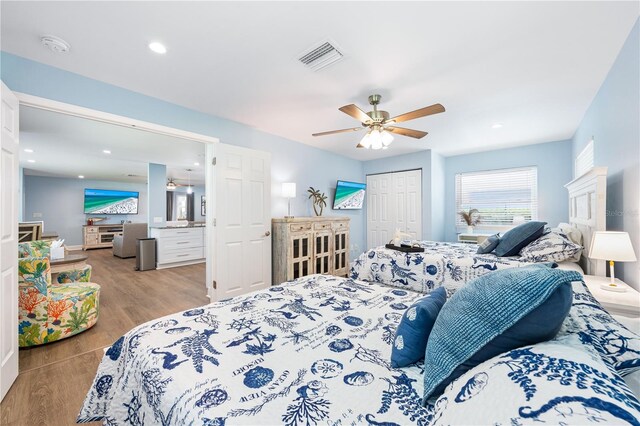 bedroom with light wood finished floors, visible vents, ceiling fan, a closet, and recessed lighting