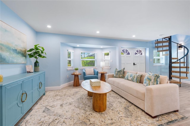 living area with a healthy amount of sunlight, light wood-style flooring, stairway, and recessed lighting