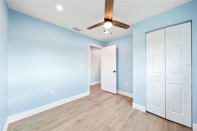 unfurnished bedroom with baseboards, visible vents, a ceiling fan, light wood-type flooring, and a closet