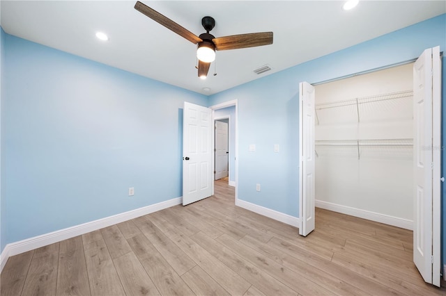 unfurnished bedroom featuring light wood-type flooring, a closet, visible vents, and baseboards