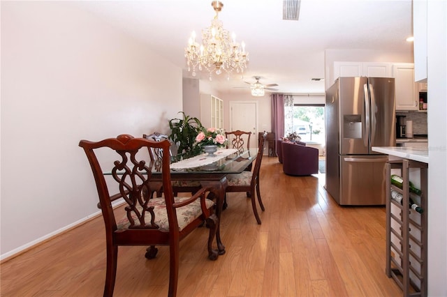 dining space featuring light hardwood / wood-style floors and ceiling fan with notable chandelier