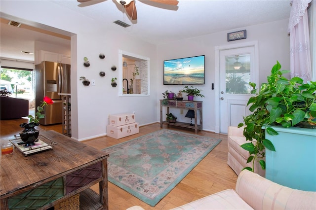 living room with light wood-type flooring and ceiling fan