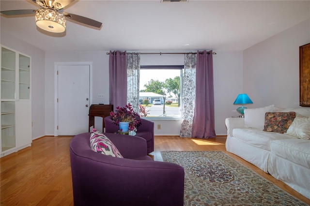 living room with ceiling fan and light wood-type flooring