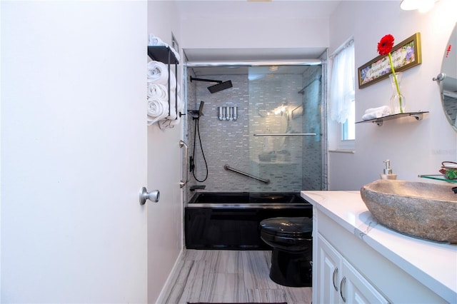 full bathroom with vanity, toilet, and enclosed tub / shower combo