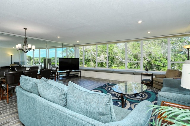 living room featuring a healthy amount of sunlight, wood-type flooring, and a notable chandelier