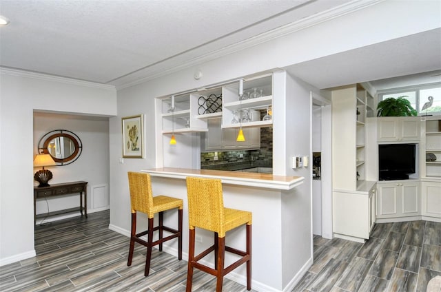 kitchen with a textured ceiling, backsplash, and a kitchen bar