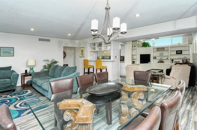 living room featuring a notable chandelier, a textured ceiling, and wood-type flooring