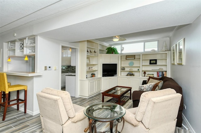 living room featuring ornamental molding, hardwood / wood-style flooring, and a textured ceiling