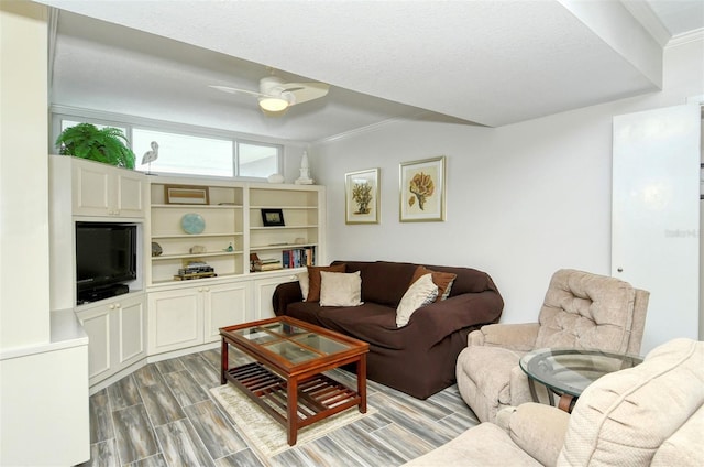 living room with ceiling fan, ornamental molding, hardwood / wood-style flooring, and a textured ceiling