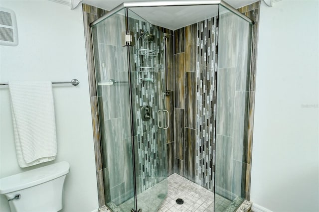 bathroom with a shower with door and toilet