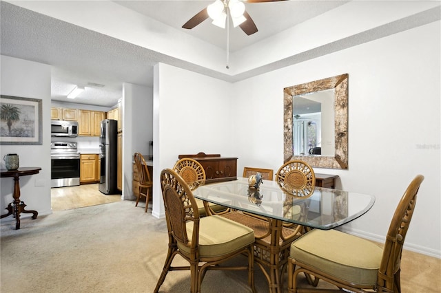 dining room with ceiling fan, a textured ceiling, and light hardwood / wood-style flooring