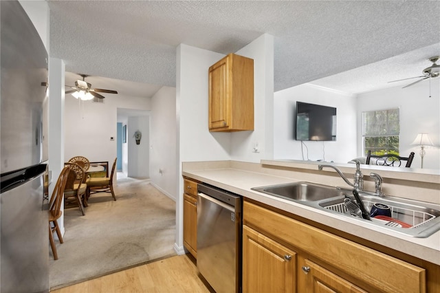 kitchen featuring light carpet, a textured ceiling, ceiling fan, and stainless steel appliances