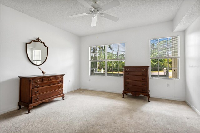 carpeted spare room with a textured ceiling and ceiling fan