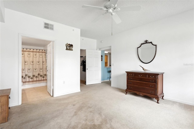 carpeted bedroom with connected bathroom, ceiling fan, and a textured ceiling