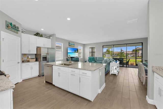 kitchen with stainless steel appliances, white cabinetry, and sink