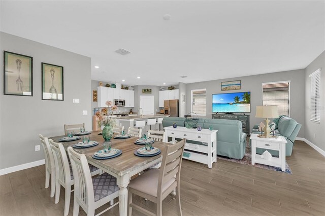 dining room with light hardwood / wood-style floors and sink