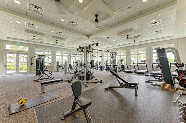 exercise room with french doors, a paneled ceiling, ceiling fan, and a raised ceiling