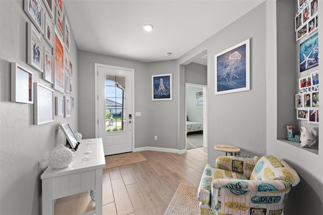 doorway featuring light wood-type flooring and baseboards