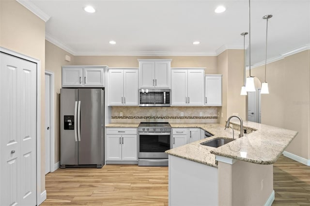 kitchen featuring light stone countertops, white cabinets, appliances with stainless steel finishes, sink, and hanging light fixtures