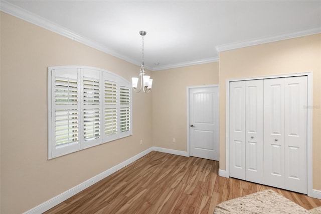 unfurnished dining area featuring a chandelier, light hardwood / wood-style flooring, and ornamental molding