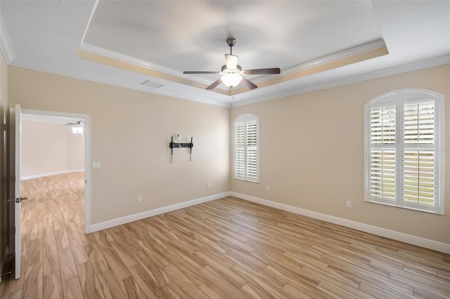 unfurnished room with ornamental molding and a raised ceiling