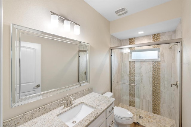 bathroom with a shower with door, toilet, and vanity