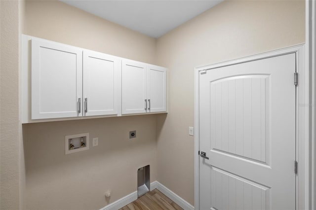 clothes washing area with light wood-type flooring, hookup for a washing machine, hookup for an electric dryer, and cabinets