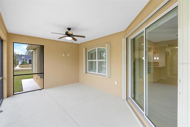 unfurnished sunroom with ceiling fan