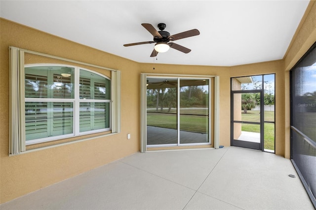 unfurnished sunroom featuring ceiling fan