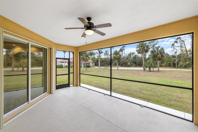 unfurnished sunroom with ceiling fan and a wealth of natural light