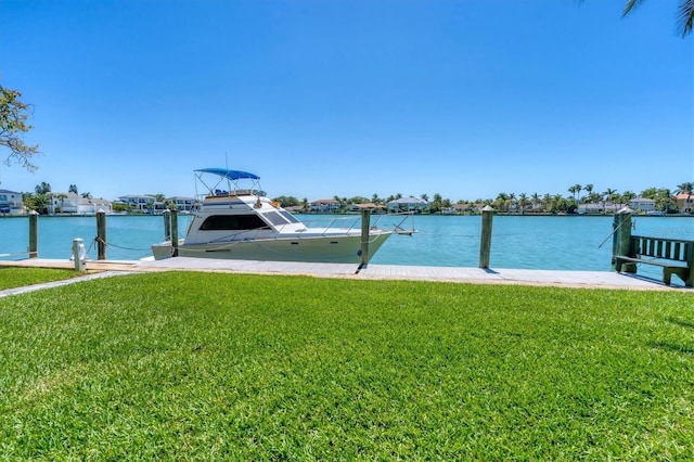 view of dock featuring a lawn and a water view