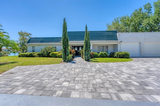 ranch-style home featuring a garage and a front yard