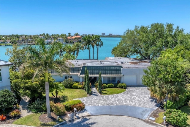 ranch-style home with a water view and a front lawn