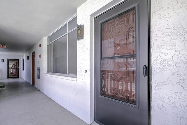 doorway to property featuring visible vents and stucco siding