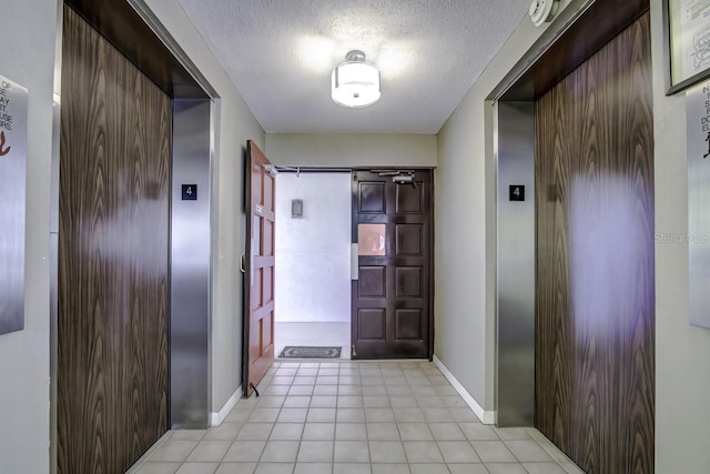 entryway featuring elevator, a textured ceiling, and a barn door