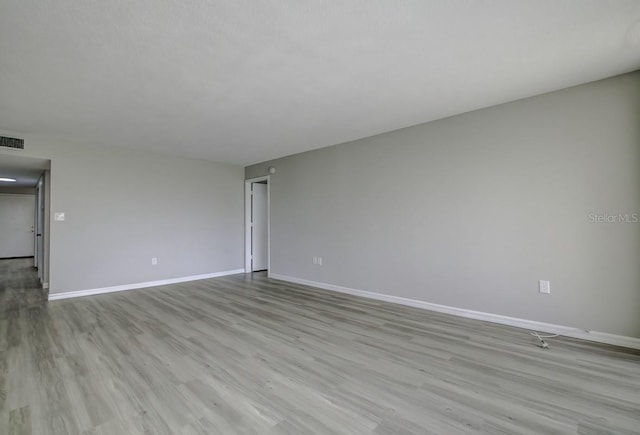 unfurnished room featuring baseboards and wood finished floors