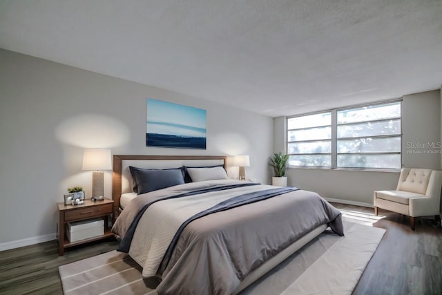 bedroom featuring baseboards and wood finished floors