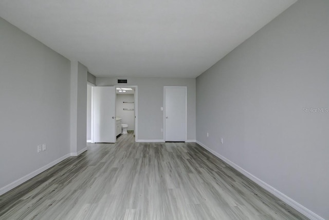 unfurnished living room with light wood-style flooring, visible vents, and baseboards