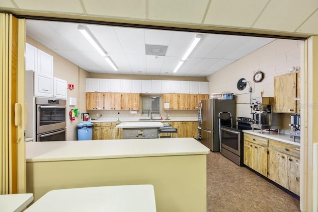 kitchen with white cabinetry, sink, kitchen peninsula, and appliances with stainless steel finishes